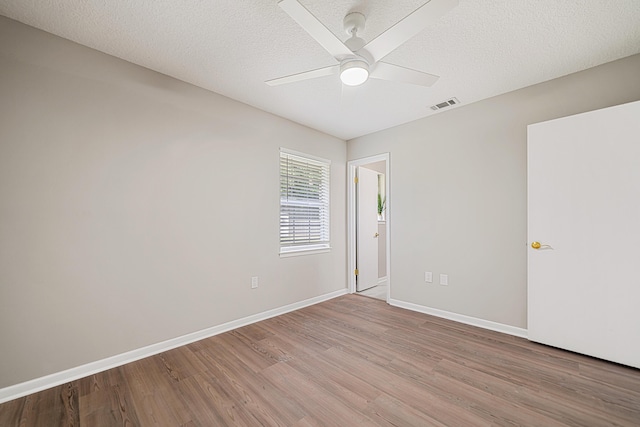 2899 Wisteria Ave, Crestview, FL 32539 - unfurnished room featuring light wood-style floors, ceiling fan, baseboards, and a textured ceiling