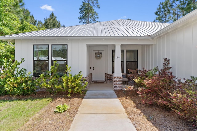 entrance to property with board and batten siding and metal roof