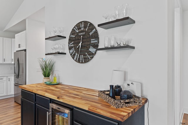 kitchen featuring wooden counters, stainless steel refrigerator with ice dispenser, and open shelves