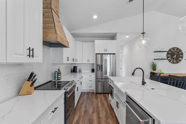 kitchen featuring lofted ceiling, white cabinetry, a sink, appliances with stainless steel finishes, and custom exhaust hood