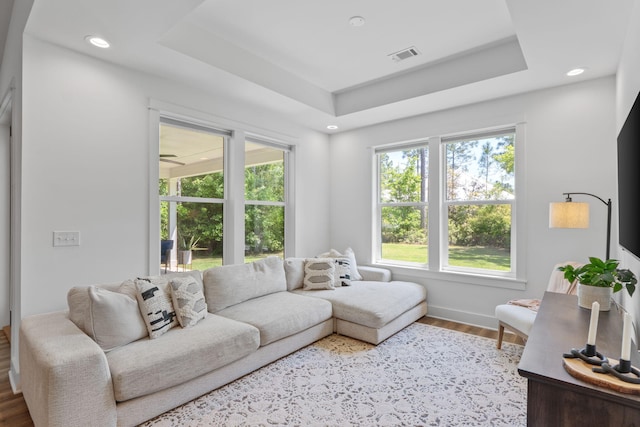 living room featuring visible vents, wood finished floors, a tray ceiling, and recessed lighting