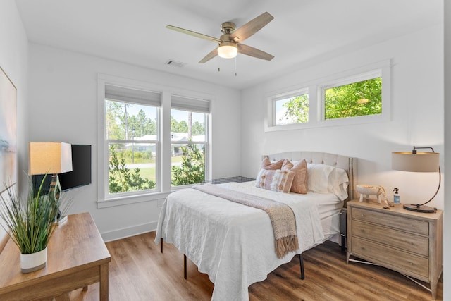bedroom with visible vents, ceiling fan, wood finished floors, and baseboards