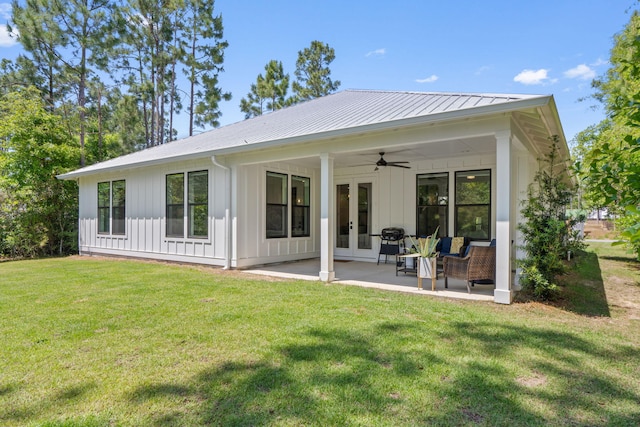 back of property featuring board and batten siding, a patio area, a lawn, a ceiling fan, and french doors