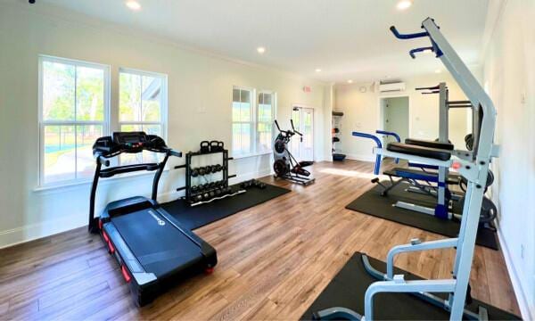 workout area featuring baseboards, recessed lighting, wood finished floors, and a wall mounted air conditioner