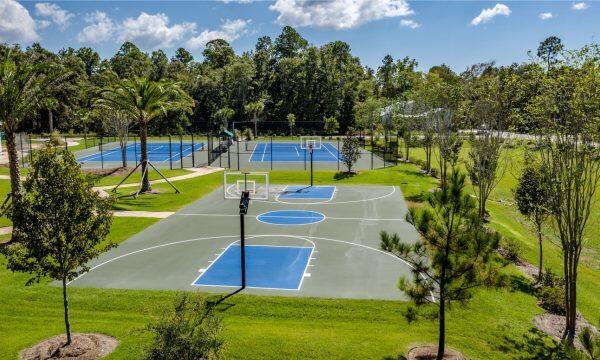 view of basketball court with a lawn, community basketball court, and fence