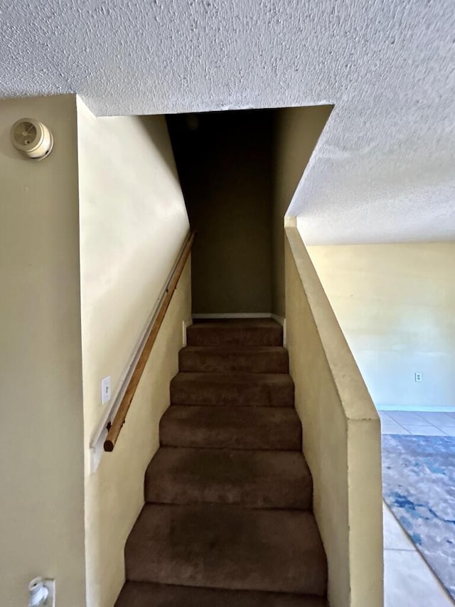 staircase with a textured ceiling