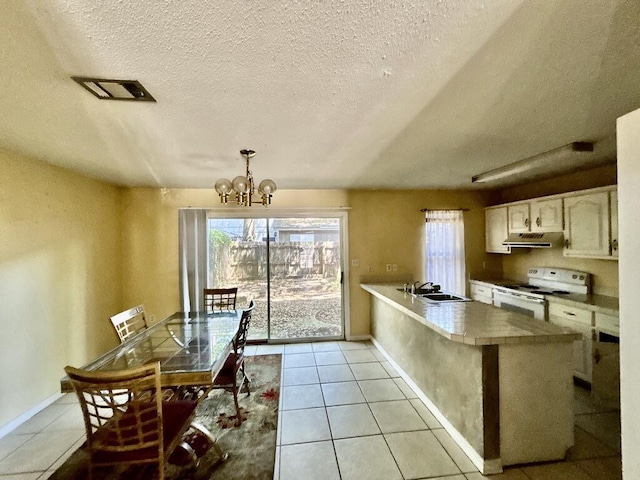 kitchen featuring an inviting chandelier, white electric stove, a peninsula, a textured ceiling, and under cabinet range hood