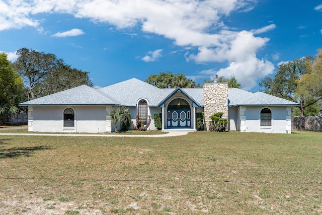 809 Main St, Destin, FL 32541 - ranch-style home featuring a front yard, a shingled roof, a chimney, fence, and stucco siding