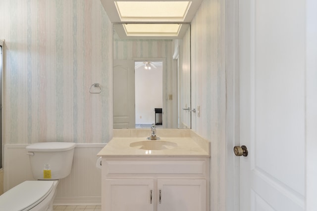 809 Main St, Destin, FL 32541 - bathroom with vanity, wallpapered walls, tile patterned floors, toilet, and wainscoting