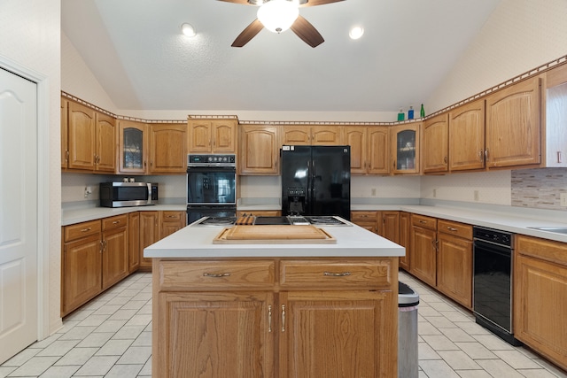 809 Main St, Destin, FL 32541 - kitchen with light tile patterned floors, ceiling fan, black appliances, vaulted ceiling, and a kitchen island
