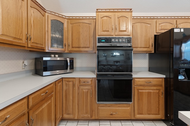 809 Main St, Destin, FL 32541 - kitchen with light countertops, glass insert cabinets, and black appliances