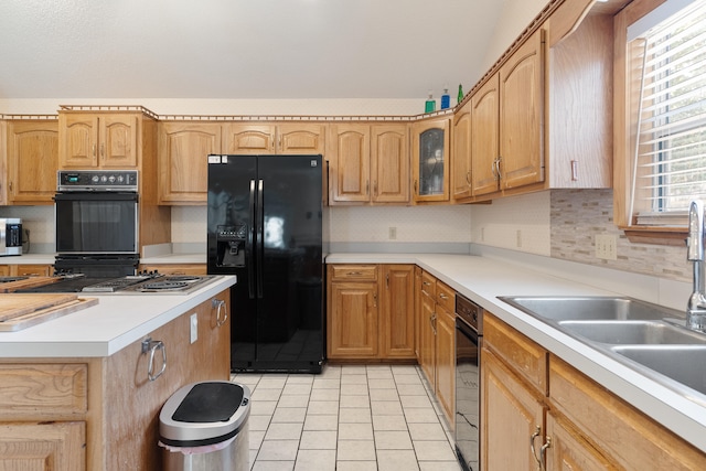 809 Main St, Destin, FL 32541 - kitchen with glass insert cabinets, a sink, light countertops, black appliances, and light tile patterned flooring