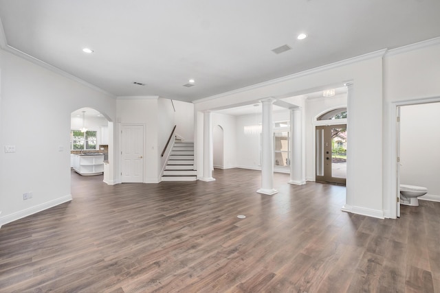 237 Matties Way, Destin, FL 32541 - unfurnished living room with plenty of natural light, crown molding, stairway, dark wood-style flooring, and arched walkways