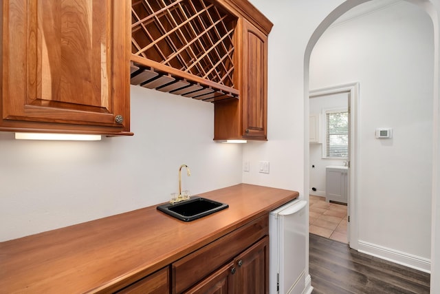 237 Matties Way, Destin, FL 32541 - indoor wet bar with fridge, arched walkways, dark wood-type flooring, and baseboards