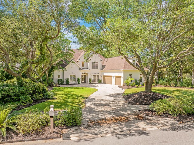 237 Matties Way, Destin, FL 32541 - view of front of home with stucco siding, a garage, driveway, and a front lawn