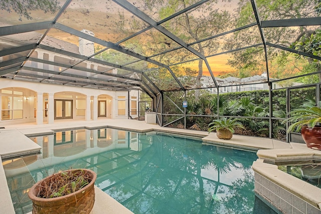 237 Matties Way, Destin, FL 32541 - pool at dusk with a patio, glass enclosure, french doors, and a pool with connected hot tub