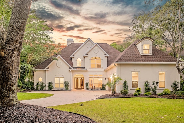 237 Matties Way, Destin, FL 32541 - view of front of house with stucco siding, concrete driveway, a chimney, and a yard