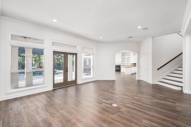 237 Matties Way, Destin, FL 32541 - unfurnished living room with crown molding, arched walkways, stairs, dark wood-style floors, and baseboards