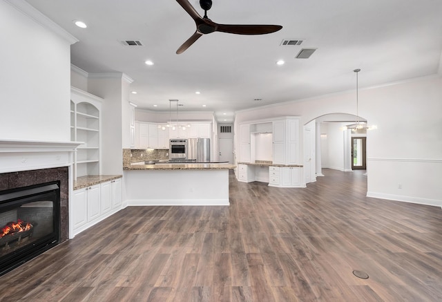 237 Matties Way, Destin, FL 32541 - unfurnished living room featuring ornamental molding, ceiling fan, a tiled fireplace, arched walkways, and recessed lighting