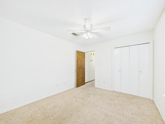 unfurnished bedroom featuring a closet, baseboards, carpet flooring, visible vents, and ceiling fan