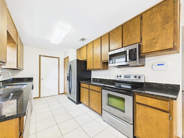 kitchen featuring a sink, visible vents, appliances with stainless steel finishes, and brown cabinets