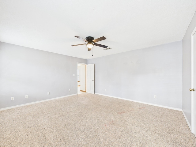 carpeted empty room with visible vents, baseboards, and a ceiling fan