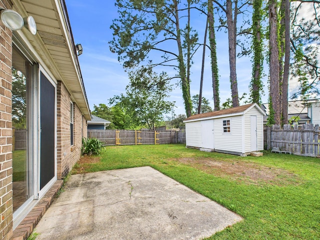 view of yard with a shed, a patio, a fenced backyard, and an outbuilding