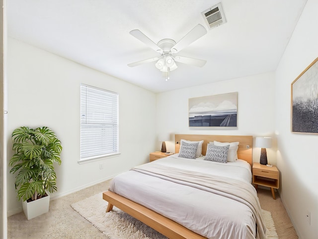 carpeted bedroom with visible vents, baseboards, and ceiling fan