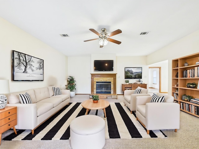 living area with visible vents, ceiling fan, and a fireplace