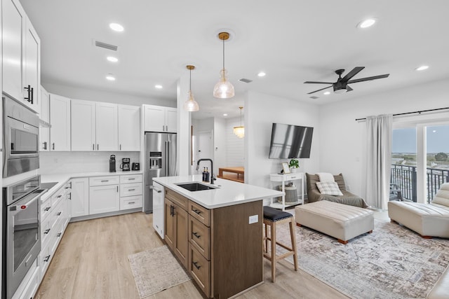 34 Gulf Breeze Ct, Destin, FL 32541 - kitchen with stainless steel appliances, open floor plan, light wood-style floors, and a sink