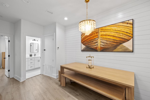 34 Gulf Breeze Ct, Destin, FL 32541 - dining area with visible vents, baseboards, an inviting chandelier, light wood-style floors, and wood walls