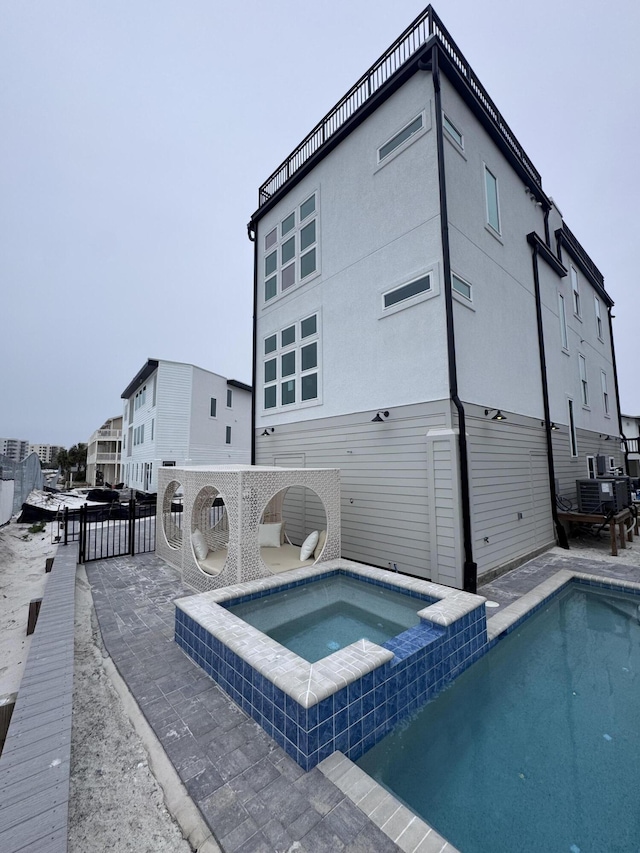 34 Gulf Breeze Ct, Destin, FL 32541 - back of house with a patio area, a pool with connected hot tub, and fence