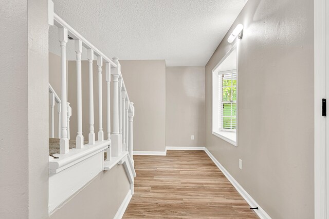 5700 Country Squire Dr, Milton, FL 32570 - unfurnished room with light wood-style floors, baseboards, stairs, and a textured ceiling