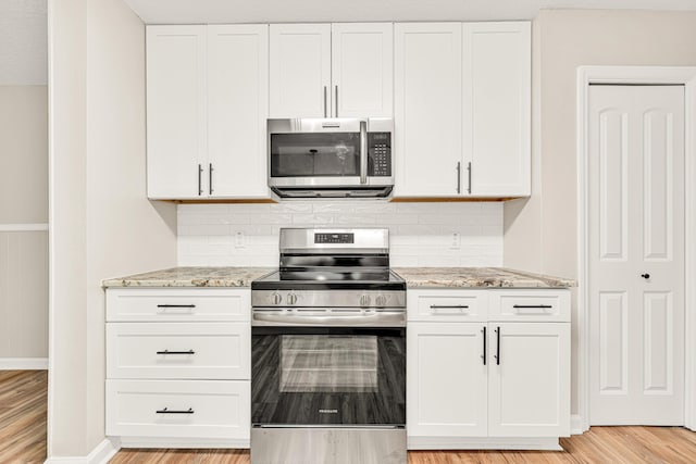 5700 Country Squire Dr, Milton, FL 32570 - kitchen with white cabinets, light stone countertops, backsplash, and appliances with stainless steel finishes