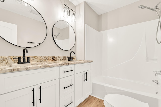 5700 Country Squire Dr, Milton, FL 32570 - full bath featuring double vanity, toilet, shower / bathtub combination, a sink, and wood finished floors