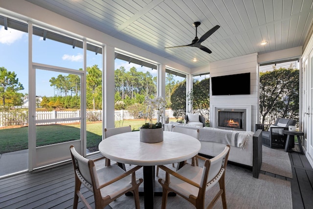 141 Sandchase Cir, Watersound, FL 32461 - sunroom with outdoor dining space, ceiling fan, a large fireplace, and hardwood / wood-style flooring