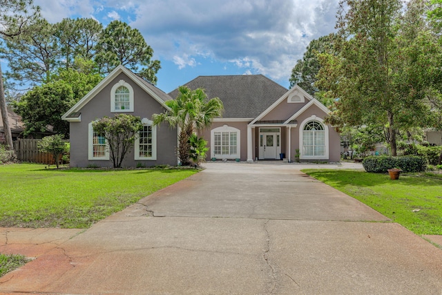 4030 Indian Trl, Destin, FL 32541 - view of front of house with a front yard, driveway, stucco siding, and fence