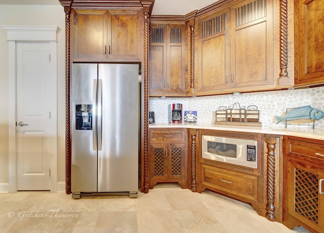 11807 Front Beach Rd Unit 2104, Panama City Beach, FL 32407 - kitchen with brown cabinetry, white microwave, light countertops, backsplash, and stainless steel refrigerator with ice dispenser