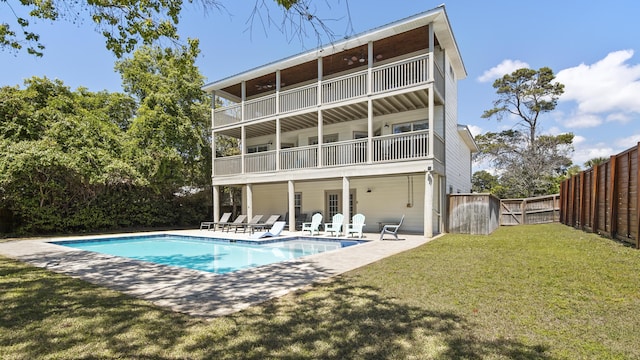 rear view of house featuring a fenced backyard, a patio area, a lawn, a balcony, and an outdoor pool