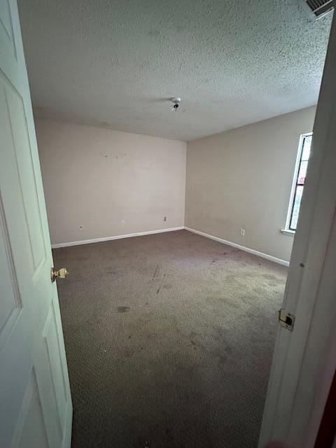 592 E Robinson Ave, Crestview, FL 32539 - spare room featuring visible vents, baseboards, carpet, and a textured ceiling