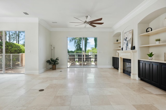 unfurnished living room featuring ornamental molding, a ceiling fan, plenty of natural light, and a glass covered fireplace