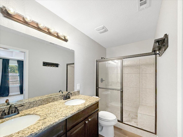 2055 Bright Water Dr, Gulf Breeze, FL 32563 - full bathroom with a shower stall, toilet, double vanity, and a textured ceiling