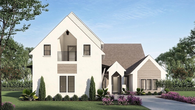 view of front of property with roof with shingles, a front lawn, and a balcony
