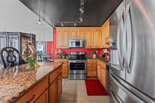 11619 Front Beach Rd Unit 201, Panama City Beach, FL 32407 - kitchen with dark stone countertops, light tile patterned floors, hanging light fixtures, and appliances with stainless steel finishes