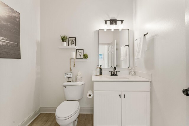 332 Somerset Bridge Rd, Santa Rosa Beach, FL 32459 - half bath with toilet, vanity, wood finished floors, and baseboards