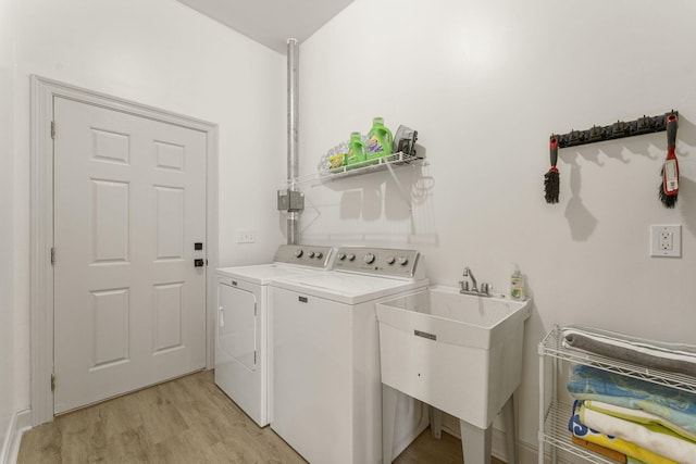 332 Somerset Bridge Rd, Santa Rosa Beach, FL 32459 - laundry room with laundry area, light wood finished floors, a sink, and washer and clothes dryer