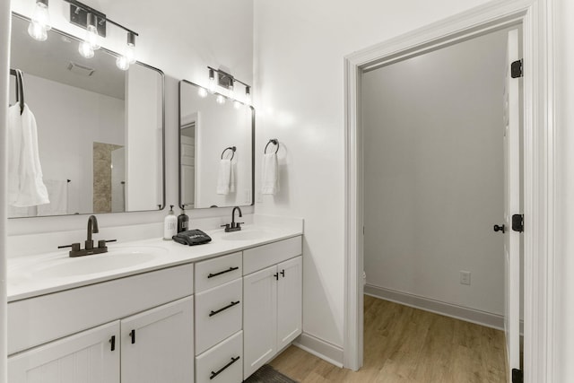 332 Somerset Bridge Rd, Santa Rosa Beach, FL 32459 - bathroom featuring a sink, visible vents, double vanity, and wood finished floors