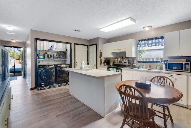 322 Apple Dr, Crestview, FL 32536 - kitchen featuring light countertops, a textured ceiling, white cabinetry, washer and clothes dryer, and stainless steel appliances