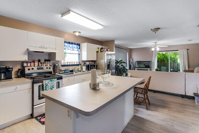 322 Apple Dr, Crestview, FL 32536 - kitchen with light wood finished floors, plenty of natural light, under cabinet range hood, and appliances with stainless steel finishes