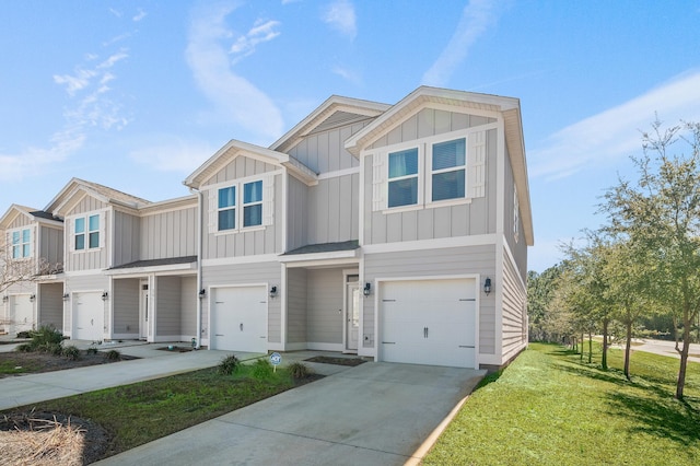 view of front of house with board and batten siding, an attached garage, a front lawn, and concrete driveway